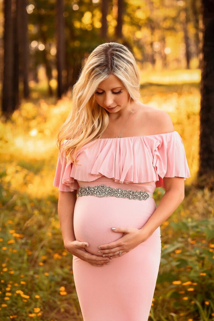 mom to be in pink maternity gown with silver belt at golden hour houston doulas